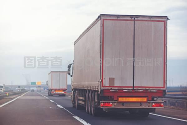 多云的下午在高速公路上行駛的商用拖車